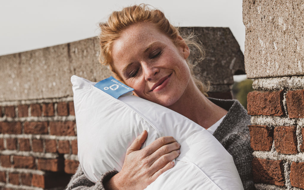 lachende dame met hoofdkussen in hand